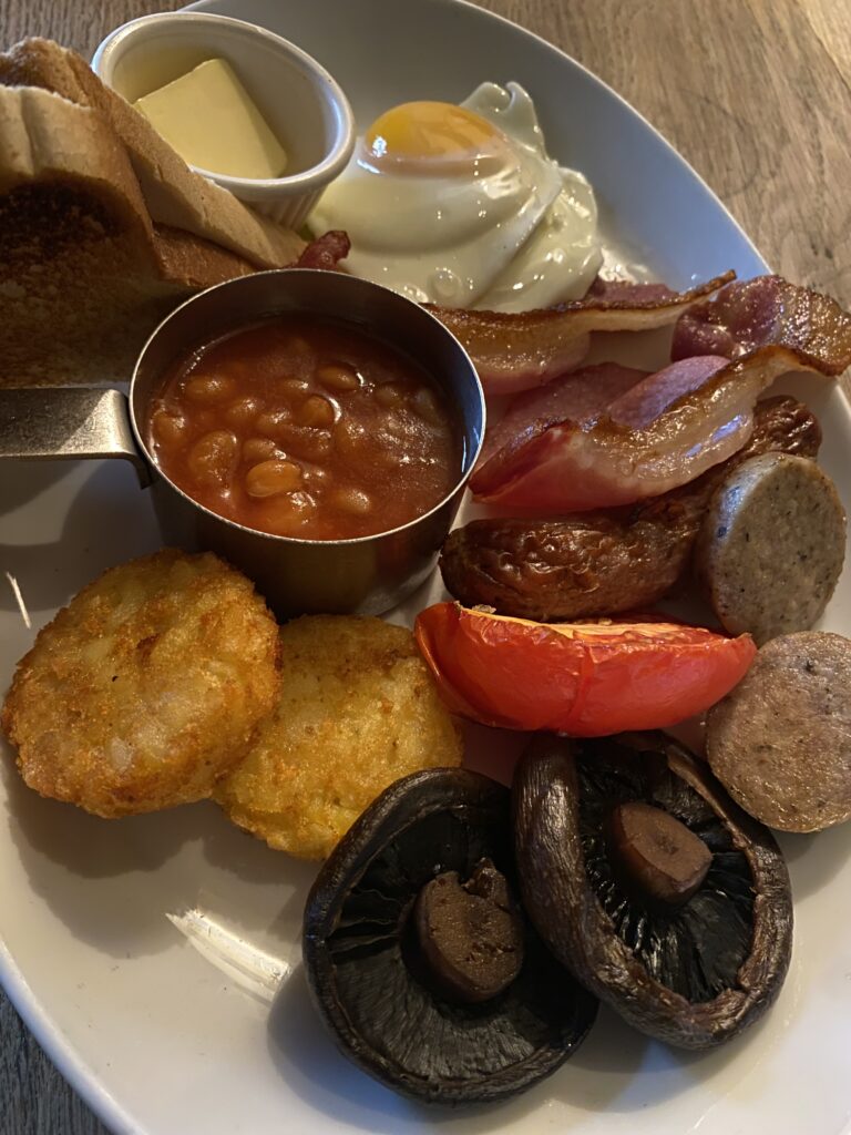 Full Scottish Breakfast mit Haggis, Bacon, Würstchen, Bohnen und Spiegelei als Stärkung während der Fernwanderung durch Schottland