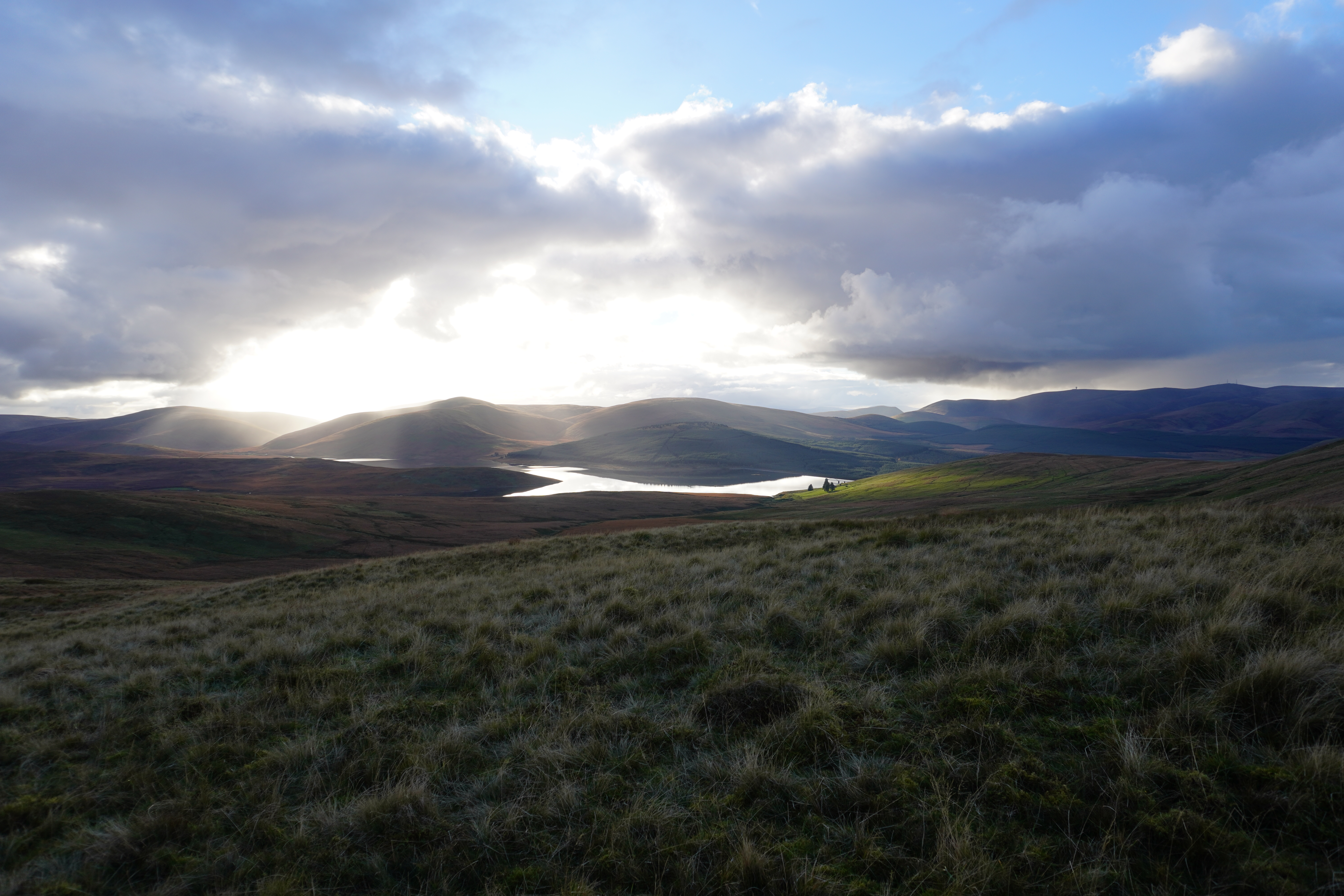 Landschaft der Scottish Uplands während unserer JOGLE Fernwanderung mit einem See und Bergen im Hintergrund