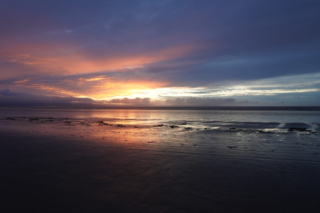 Blick auf das Meer während dem Sonnenuntergang an der Küste Südenglands während unserer JOGLE Wanderung
