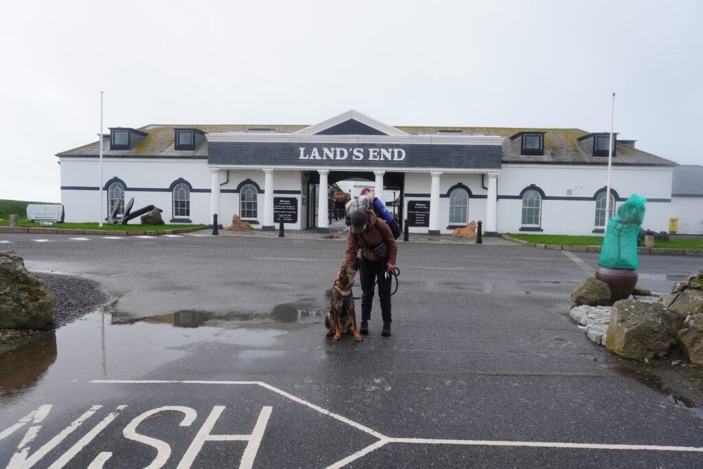 Maresa und Hund Nero vor dem Land’s End Schriftzug des Hauses am südlichsten Punkt Englands