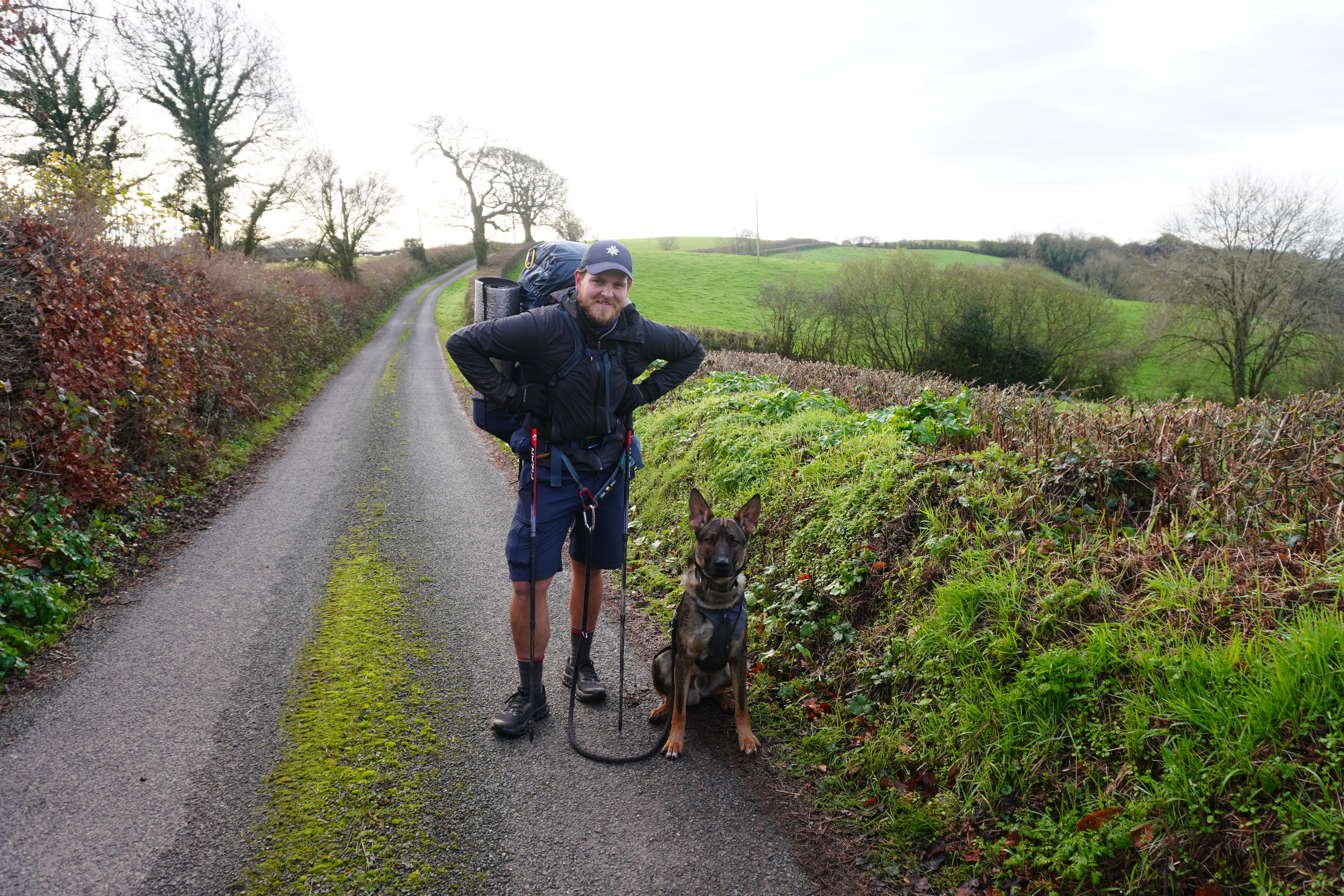 Nick mit Hund Nero in die Kamera lachend auf dem Cotswold Way während der JOGLE Fernwanderung