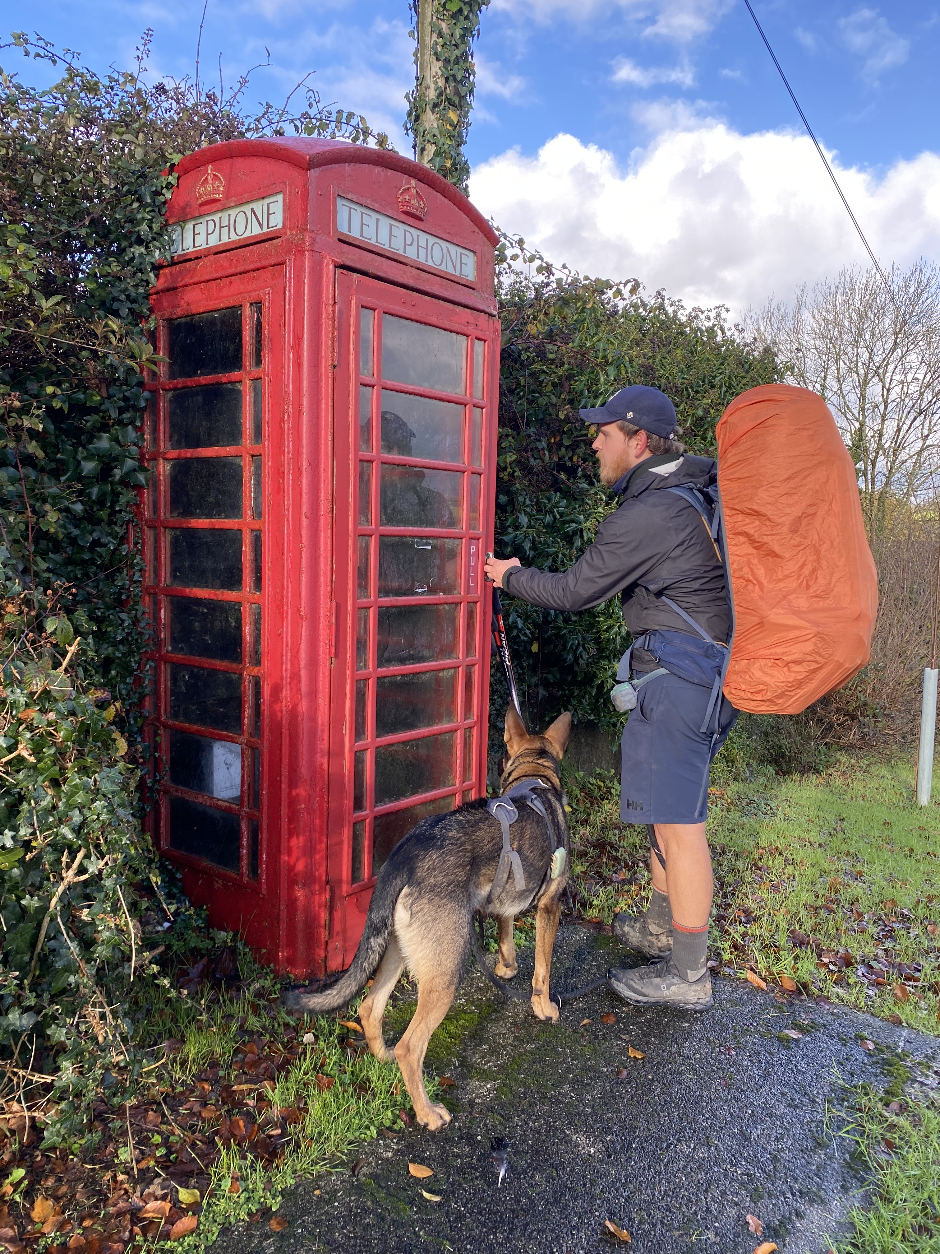 Nick und Hund Nero vor einer typischen britischen Telefonzelle in Cornwall während der JOGLE Fernwanderung